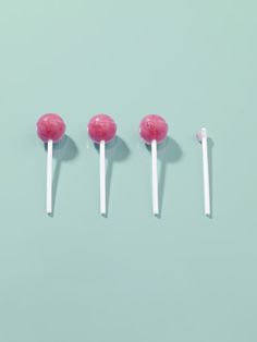 four candy lollipops are lined up in a row on a blue background