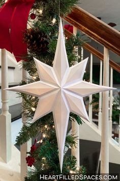 a white star hanging from the side of a christmas tree