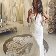 a woman is taking a selfie in her wedding dress while standing on the floor