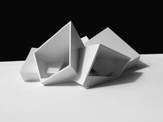 two white sculptures sitting on top of a table next to each other in black and white