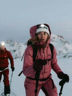 two people in ski gear walking through the snow