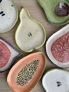 four bowls with different designs on them sitting next to each other and one has a slice of watermelon in the middle