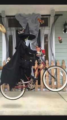 a bike with a costume on it parked in front of a house decorated for halloween