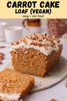 carrot cake loaf with cream cheese frosting and nuts on top, sitting on a plate