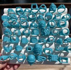 a person holding up a bunch of blue plastic rings and bracelets in their hands