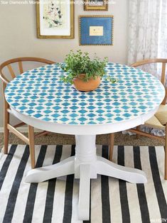 a potted plant sitting on top of a white table with blue and white tiles