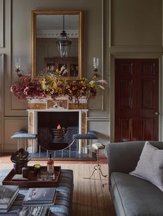 a living room filled with furniture and a fire place next to a mirror on the wall