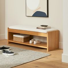 a wooden bench sitting on top of a hard wood floor next to a white rug