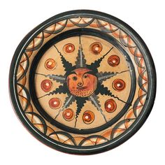 a decorative bowl with an animal face painted on the side and circles in the middle