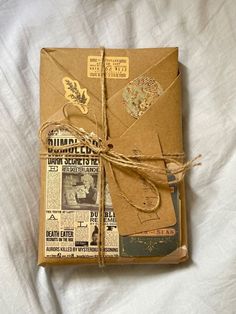 an old book wrapped in brown paper and tied with twine on top of a white sheet