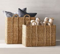 two woven baskets with decorative items in them sitting on the floor next to each other