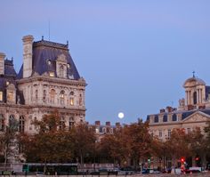 the full moon is setting over an old building in paris's champs des bouloges