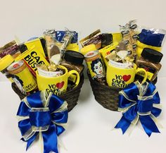 two baskets filled with coffee and snacks on top of a white table next to each other