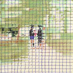 two people standing in the grass behind a mesh fence