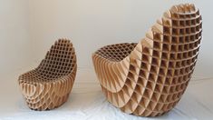 two chairs made out of cardboard sitting on top of a white sheet