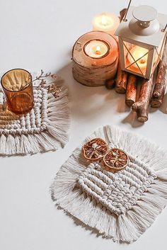 two tasselled coasters sitting on top of a table next to candle holders