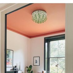 a living room filled with furniture and a lamp hanging from the ceiling over a fire place