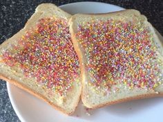 two pieces of bread with sprinkles on them sitting on a white plate