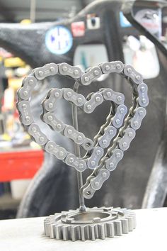 a bike chain heart sculpture on top of a table