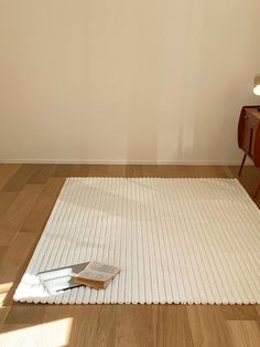 a white rug sitting on top of a hard wood floor