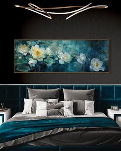 a large painting hanging above a bed in a room with black walls and blue bedspread