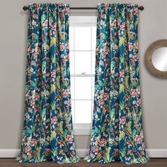 the blue floral curtains are hanging in front of a window with a mirror on it