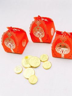 four red packets with gold coins in front of them on a white surface, one is empty and the other has chinese writing