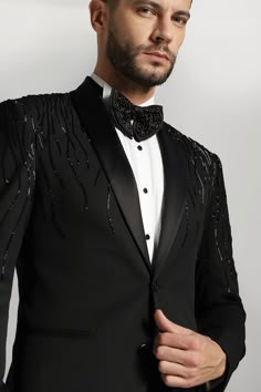 a man wearing a tuxedo and bow tie with black sequins on it