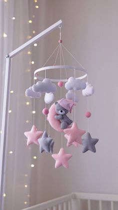 a baby crib mobile with stars and a teddy bear