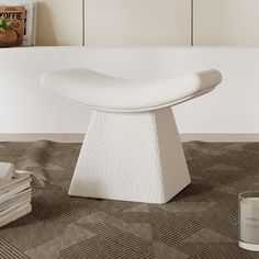 a white sculpture sitting on top of a carpeted floor next to a book shelf