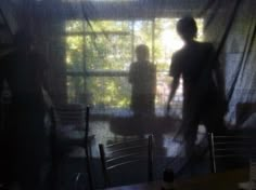 two people standing in front of a window with the curtains pulled back and sun shining through