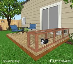 a cat sitting on top of a wooden deck next to a fenced in area