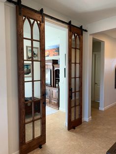 an open living room door with mirrored glass panels on the doors and wood trimmings