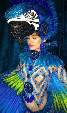 a woman in blue and green costume with feathers