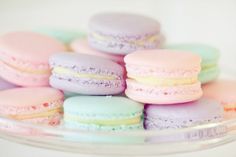 there are many different colored macaroons on the plate