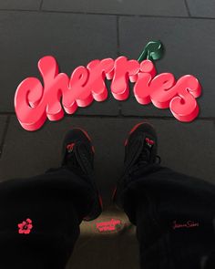 a person standing in front of a sign that says cherries on the side of their feet