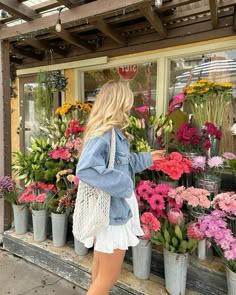 a woman standing in front of a flower shop