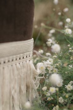 a close up of a person's leg with white flowers in the foreground