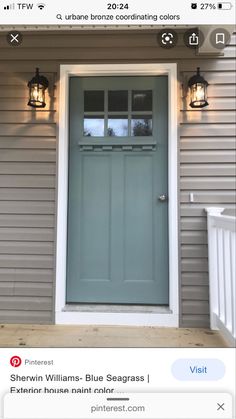 the front door of a house with two lights on each side and an open window