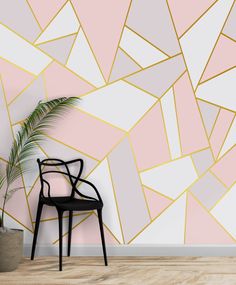 a chair sitting in front of a wall with a pink and gold geometric design on it