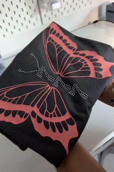 This 777 rhinestone butterfly t-shirt comes in black and blue and our new color gray and melon! The front of the shirt has big vinyl printed butterfly wings, and rhinestoned '777' with antennas used as the body. I recommend sizing up for an oversized fit. Sizing: Gildan 2x+ Comfort colors s-xl Butterfly T Shirt, Antennas, Butterfly Wings, Melon, Comfort Colors, New Color, Blue Black, Gray Color, Gender Neutral