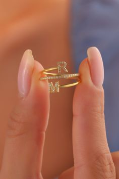 a close up of a person holding a ring with the letter n on it's side