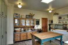 an old fashioned kitchen with lots of wood furniture and decor on the walls, along with wooden floors