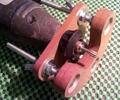 an old wooden skateboard with some metal parts on it's wheels and axles