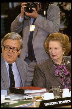 two people sitting at a table with cameras