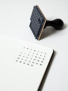 a black rubber stamp sitting on top of a notebook