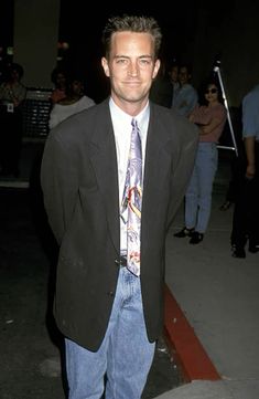 a man in a suit and tie standing on the sidewalk