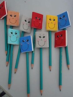 several colored pencils with faces drawn on them