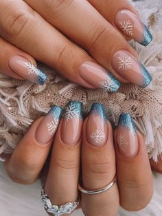 This elegant winter nail art features a glittery blue French tip with delicate white snowflakes. The clear base highlights the festive snowflakes, while the shimmering blue adds a frosty touch, perfect for a holiday or winter-themed look. Blue Christmas Nails, Snowflake Nail Design, Cute Christmas Nails, Blue Nail Designs, White Nail Designs, Blue Nail