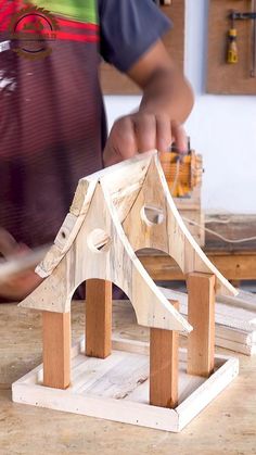 a man working on a wooden house model